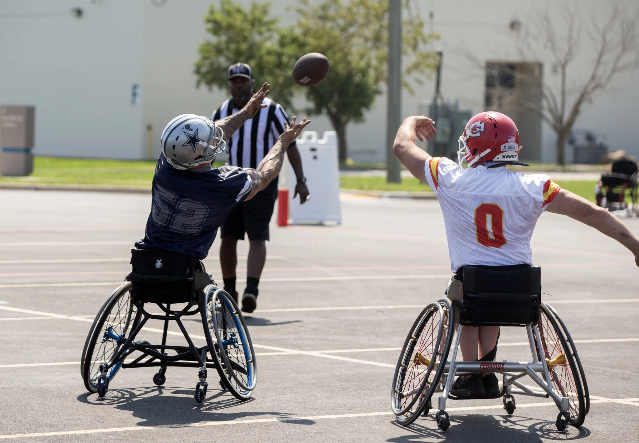 Two wheelchair football players reach for a pass during a RISE game.